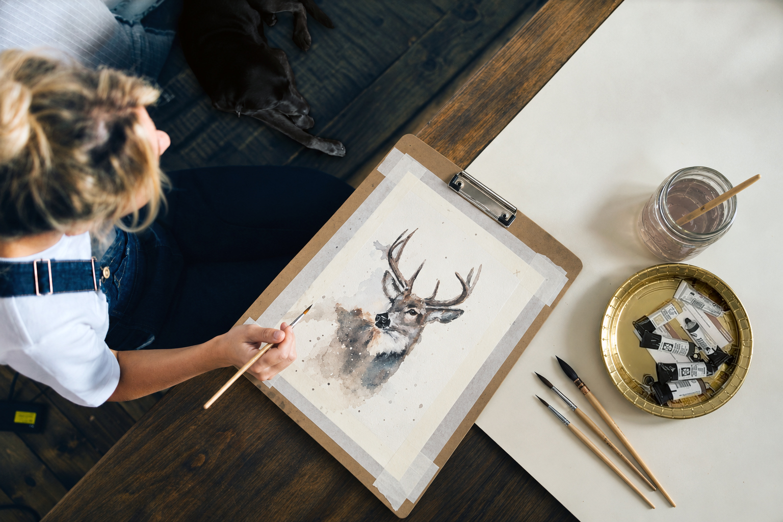 Deer watercolor study at the worktable, with brushes and paints